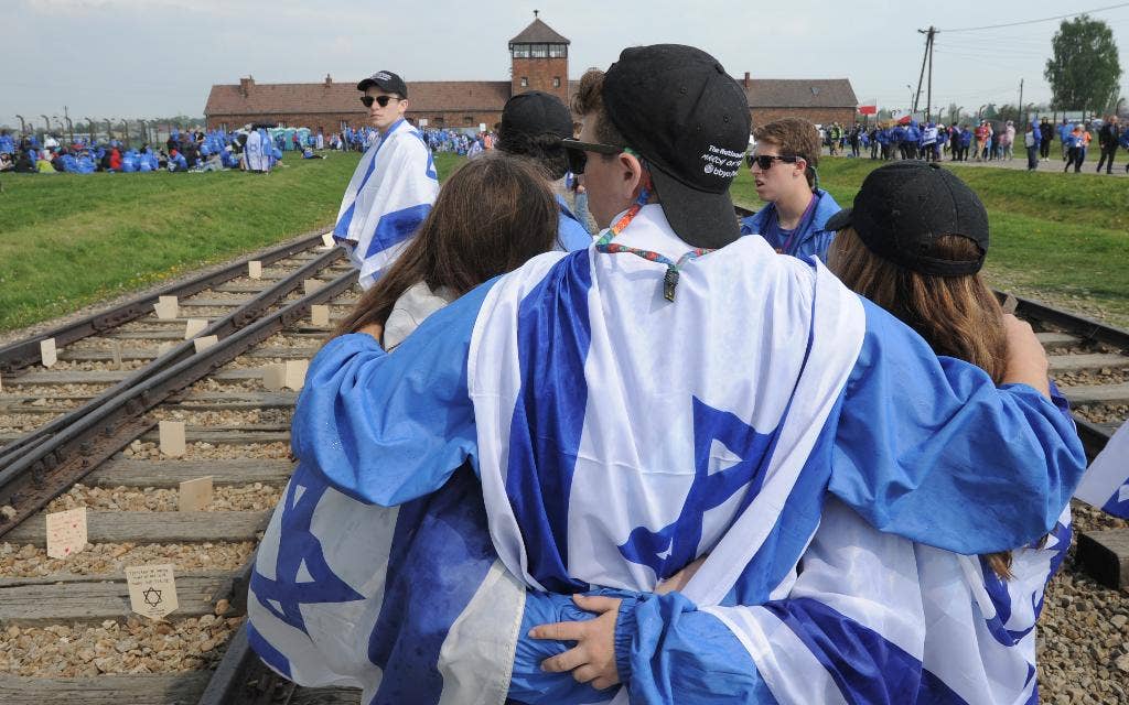 Para pengunjuk rasa di Auschwitz menghormati orang-orang Yahudi yang terbunuh dalam Holocaust