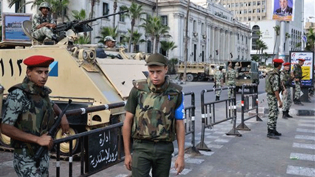 Egyptian security forces stand guard outside the courthouse in Alexandria, Egypt, during a hearing on Sept. 24.