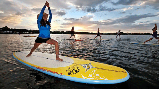 Latest Vacation Craze Gets Paddleboarders to Do Sun Salutations in the Surf