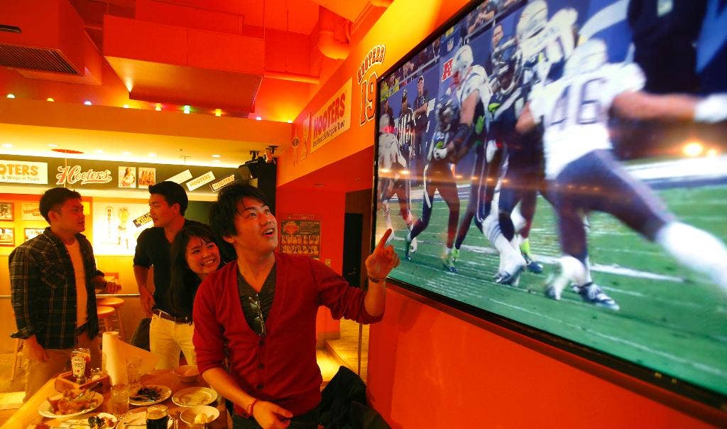 Dari Rio hingga Tokyo, penggemar olahraga bolos kerja atau menantang panasnya cuaca untuk menonton Super Bowl