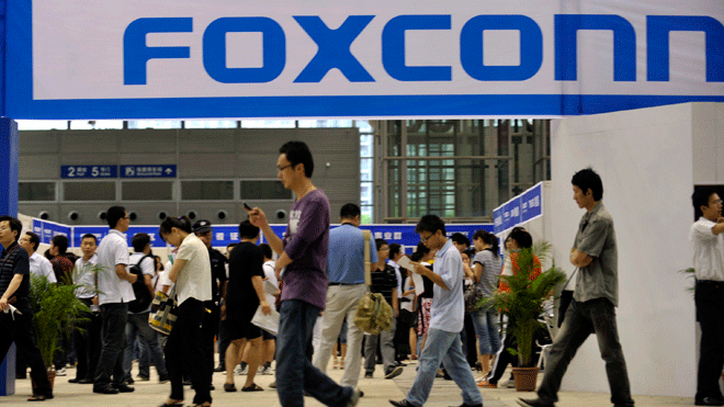 In this file photo taken on May 22, 2010, visitors to a job fair walk past the Foxconn recruitment area in Shenzhen in south China's Guangdong province.