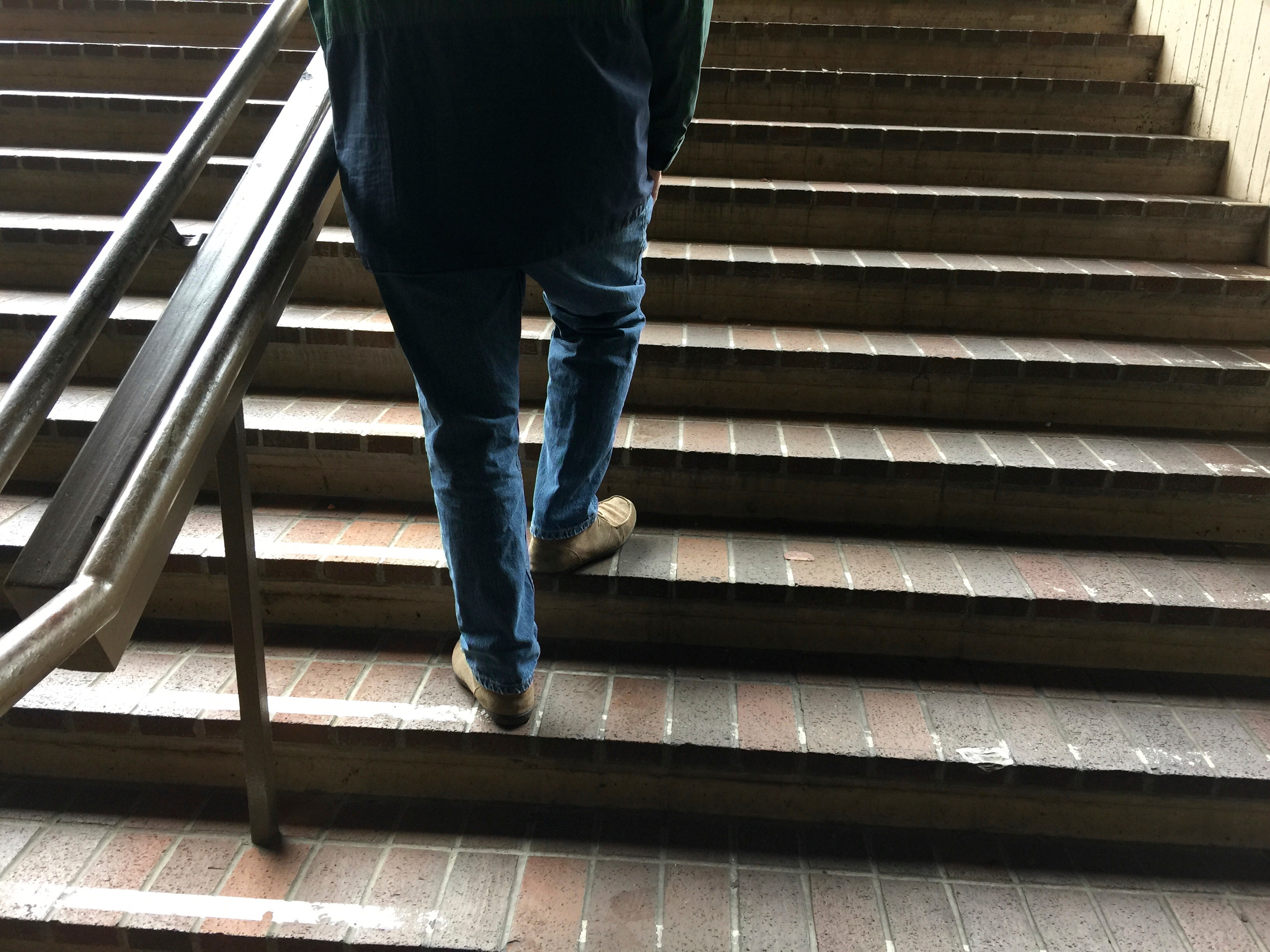 Подниматься спускаться по лестнице. Человек на ступеньках. Человек на лестнице. Парень спускается по лестнице. Ноги идут по ступенькам.