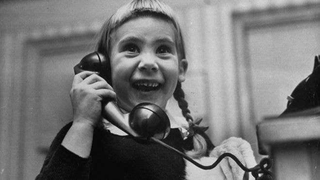 Photos of kids on the phone with Santa, 1947