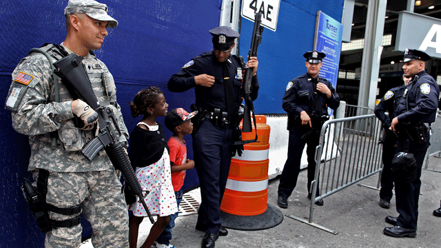 A Port Authority police officer shares a light moment with children visiting from France at commuter train station near ground zero Saturday, Sept. 10, 2011 in New York.