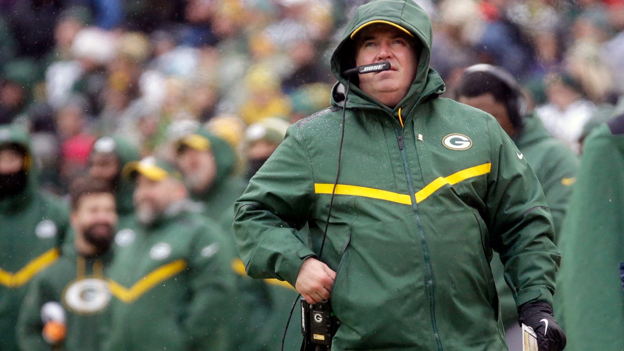 Green Bay Packers head football coach Mike McCarthy (R) gets an