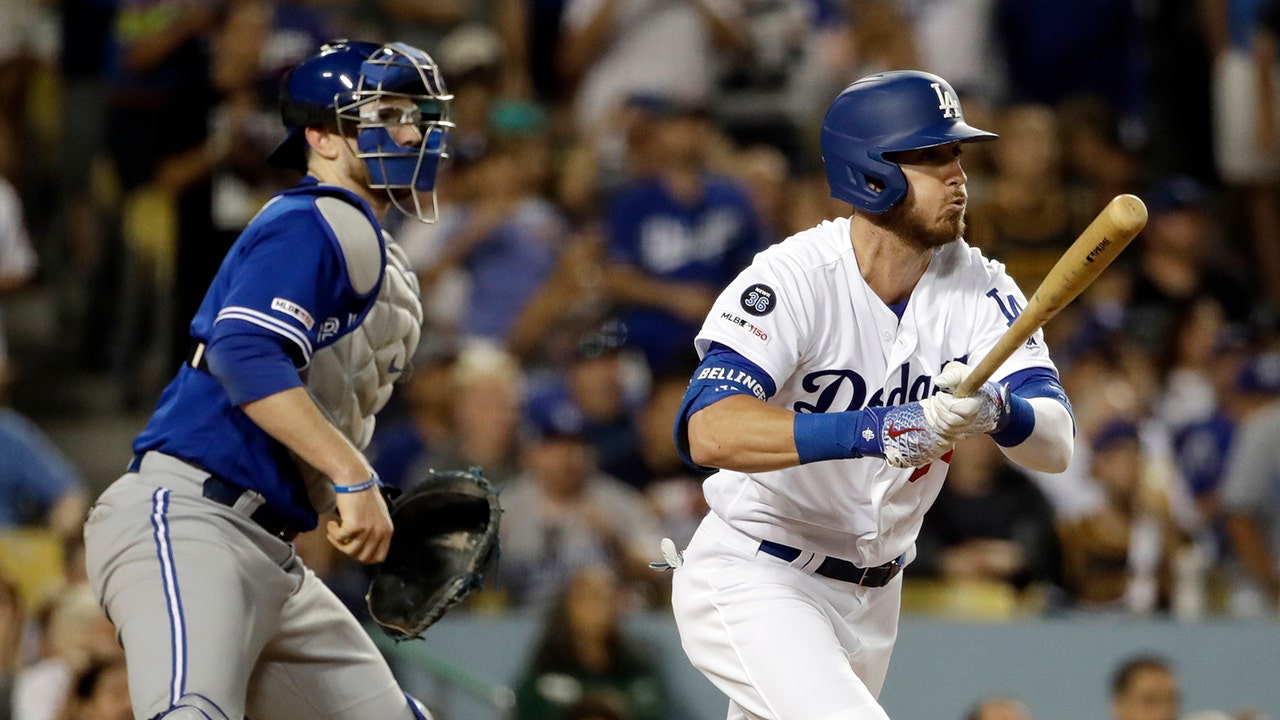 Los Angeles Dodgers centerfielder Cody Bellinger (R) goes down on