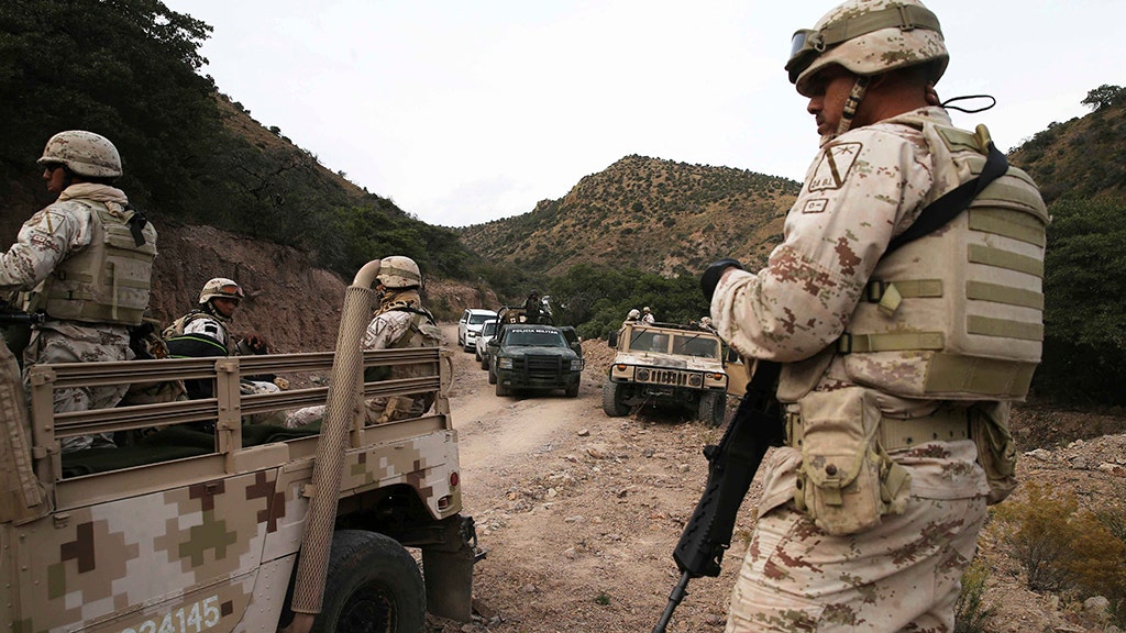 Mourners of Mexican cartel massacre victims, escorted by military, arrive for first funerals