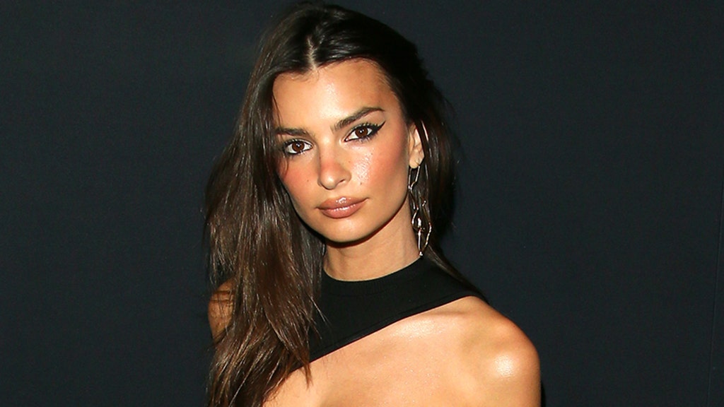 Emily Ratajkowski poses in thong bikini as she models her swimwear line's new collection