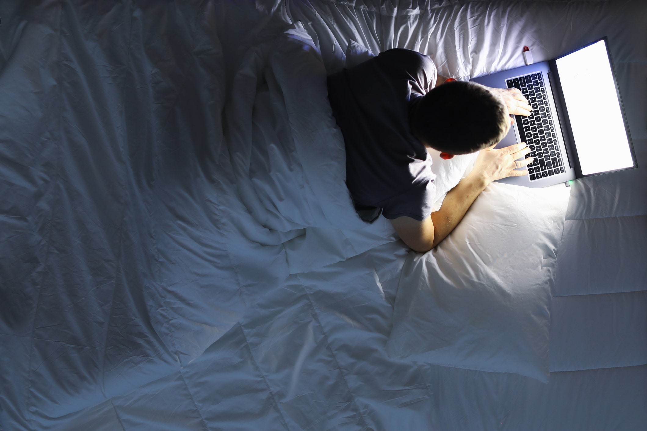Мужчина с ноутбуком в постели