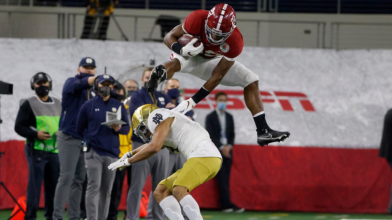 Alabama’s Najee Harris jumps over Notre Dame defender in a long run during the Rose Bowl