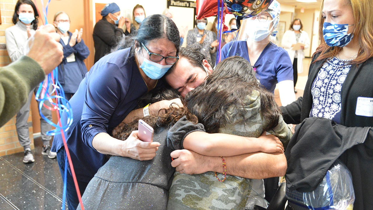Coronavirus survivor embraces daughters after months of hospitalization
