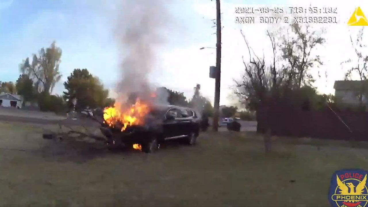 Phoenix police save driver trapped in burning car, video shows