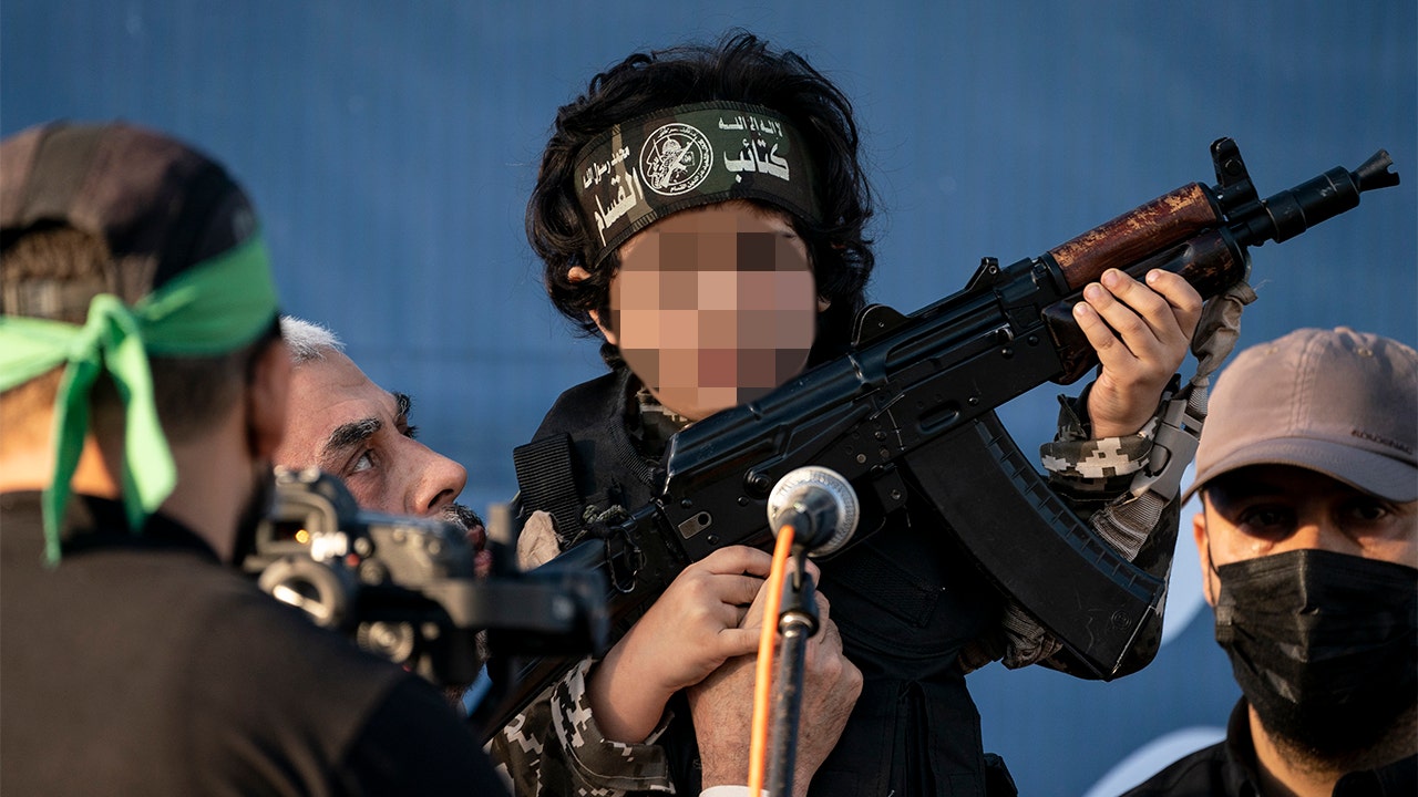 Hamas leader Sinwar hoists rifle-carrying child for cameras in Gaza City rally