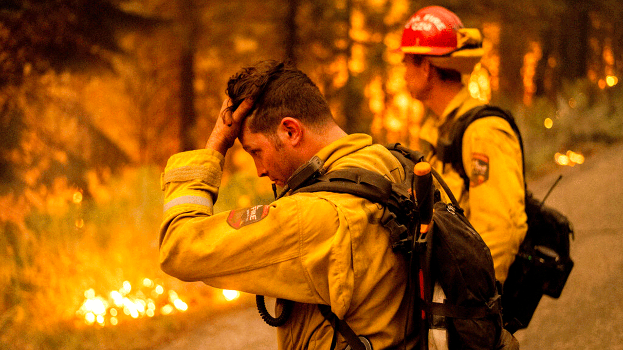 Firefighter Jesse Forbes rubs his head while battling the Dixie Fire near Prattville in Plumas County, Calif., on Friday, July 23, 2021. 