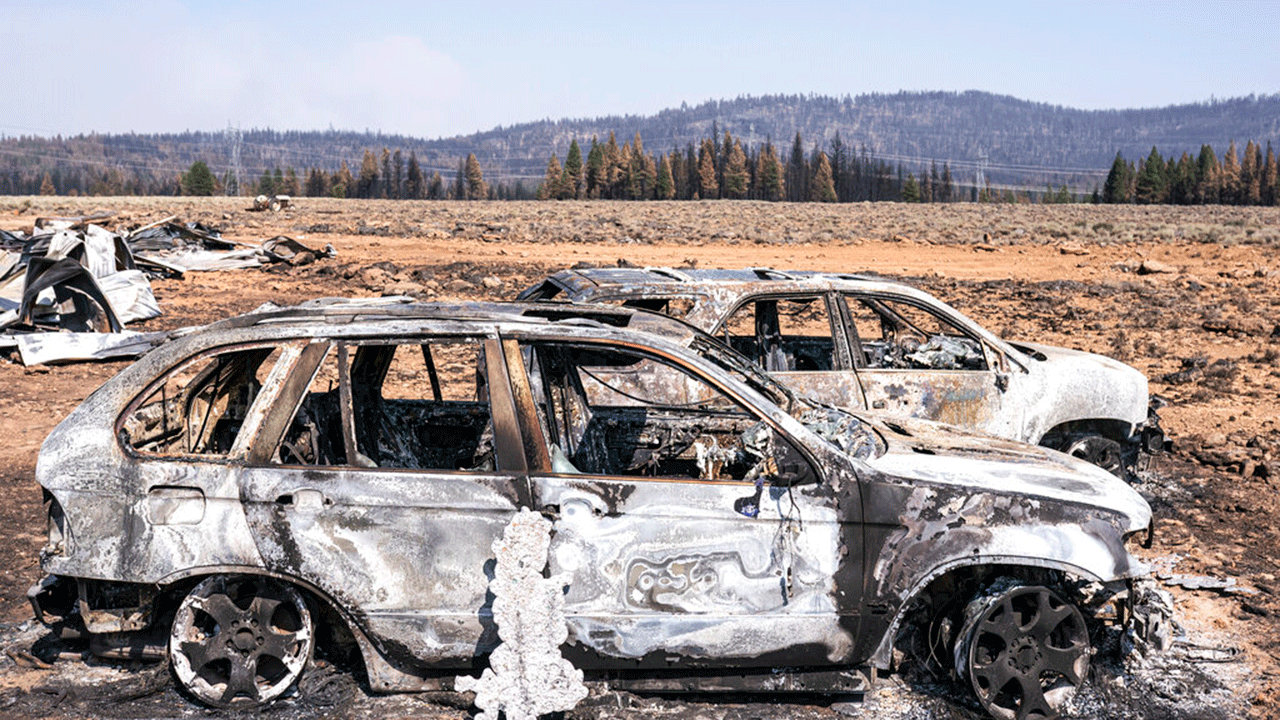 Two cars that were destroyed by the Bootleg Fire sit near damaged property Thursday, mes de julio 22, 2021, near Bly, Mineral.