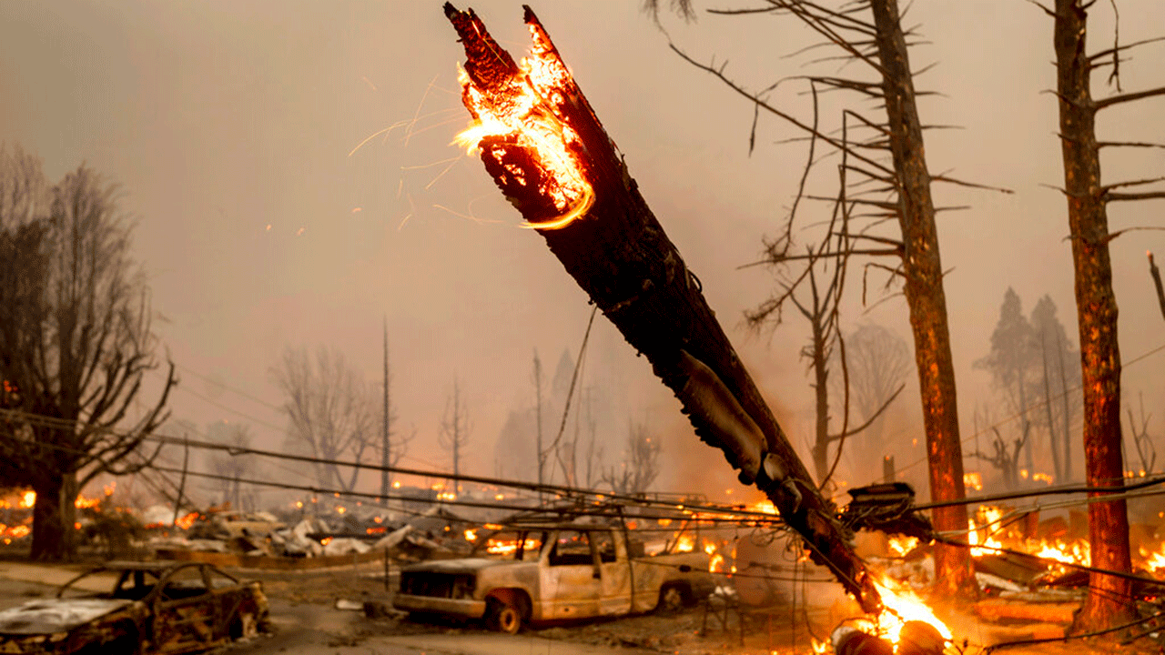 A utility pole burns as the Dixie Fire tears through the Greenville community of Plumas County, Calif., on Wednesday, Aug. 4, 2021. The fire leveled multiple historic buildings and dozens of homes in central Greenville.