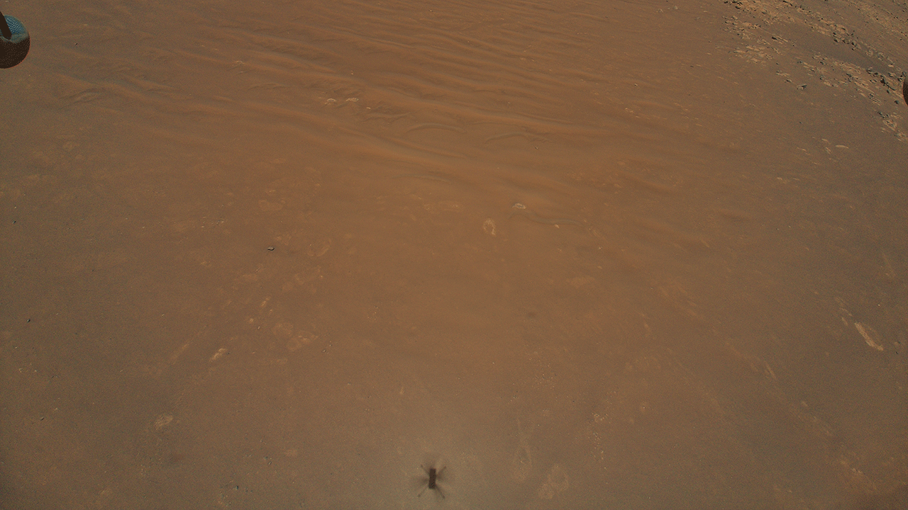 Figure 1 shows the "South Séítah" region of Jezero Crater, captured by NASA’s Ingenuity Mars Helicopter during its 11th flight on Aug. 4, 2021. At the bottom center of the image is Ingenuity’s shadow. Above it, toward the top of the frame – just beyond the dune field and right of center – is the Perseverance rover (the bright white dot).