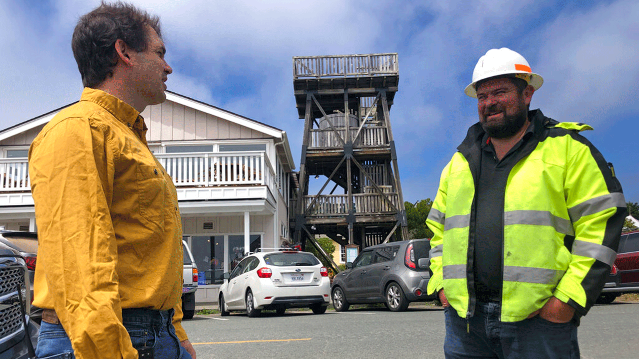 Mendocino County Supervisor Ted Williams, left, talks with Ryan Rhoades, superintendent of the Mendocino City Community Services District, which helps manage the water in the town's aquifer, in Mendocino, Calif., with an old water tower in the background on Wednesday, Aug. 4, 2021.