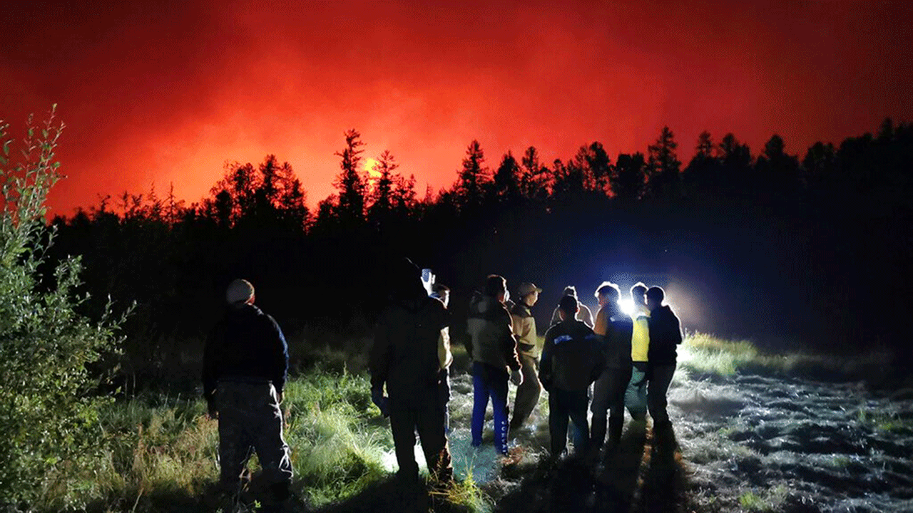 Firefighters and volunteers have a briefing as they work at the scene of forest fire at Gorny Ulus area west of Yakutsk, in Russia, Saturday, Aug. 7, 2021. Wildfires in Russia's vast Siberia region endangered several villages Saturday and prompted authorities to evacuate residents of some areas. In northeastern Siberia, 93 active forest fires burned across 1.1 million hectares (2.8 million acres) of Sakha-Yakutia, officials said, making it the worst affected region of Russia.
