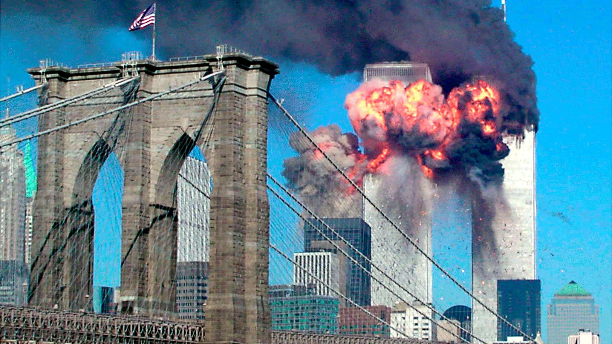 The second tower of the World Trade Center bursts into flames after being hit by a hijacked airplane in New York in this 9/11/01 file photograph. The Brooklyn bridge is seen in the foreground on 9/11, 2001.