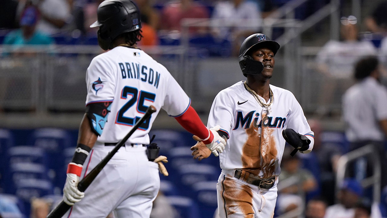 Miami Marlins' Lewis Brinson (9) strikes out with runners on base