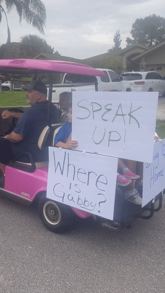 Some protesters carried signs in golf carts urging Brian Laundrie to speak up about his fianceé's disappearance. 
