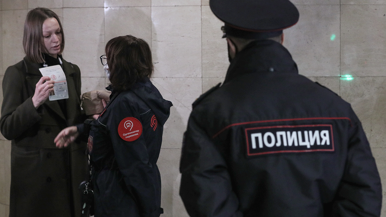 A police officer and a ticket collector enforce the face mask requirement at Trubnaya station of the Moscow Metro. Due to a surge in COVID-19 cases, the Moscow authorities has declared non-working days with pay from October 28 to November 7. Alexander Shcherbak/TASS (Photo by Alexander ShcherbakTASS via Getty Images)