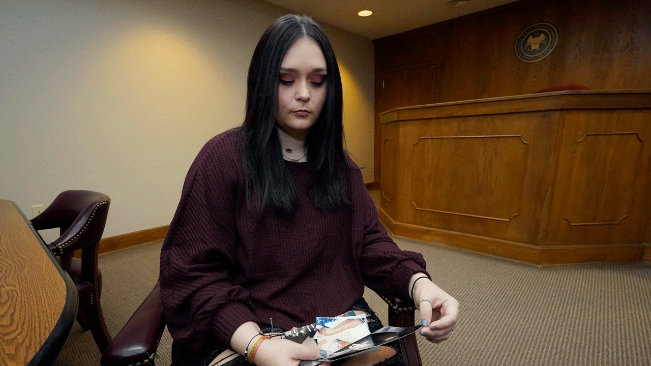 Lindsey Kirk looks at childhood photographs of herself and her late mother, Kim Kirk Cox, Saturday, Nov. 13, 2021, in New Albany, Mississippi. 