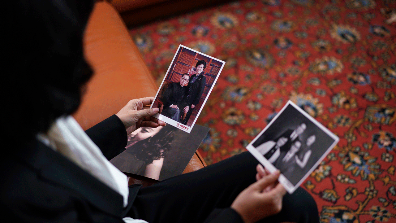 Grace Meng shows family photos during an interview with The Associated Press in Lyon, central France, Tuesday, Nov.16, 2021.?