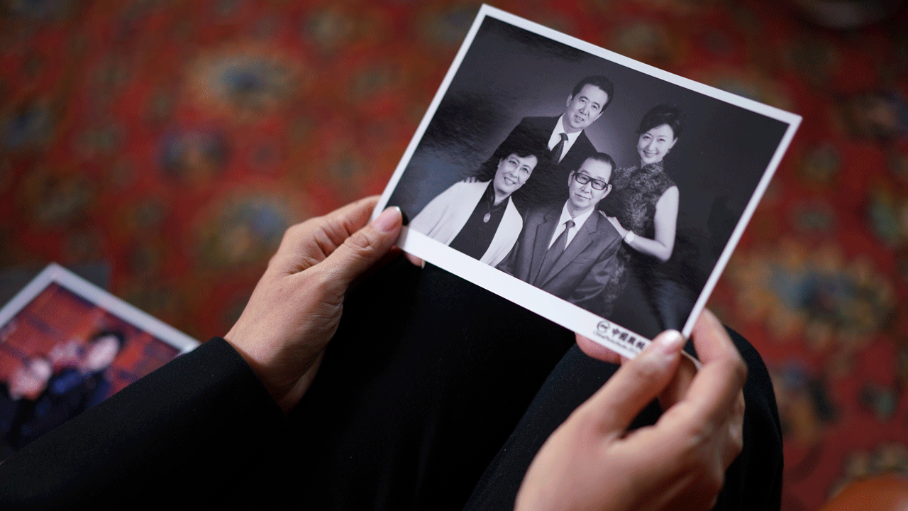 Grace Meng shows photos of her parents, first row, and her with her husband, in Lyon, central France, Tuesday, Nov.16, 2021. 