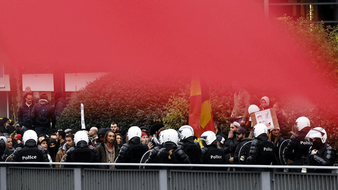 Police officers and protesters gather during a demonstration against efforts to counter the coronavirus in Brussels, Belgium, on Sunday, Nov. 21, 2021.