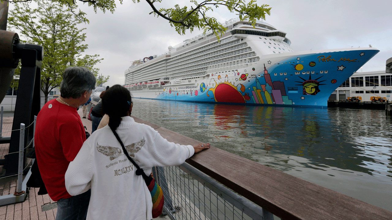 People pause to look at Norwegian Cruise Line's ship, Norwegian Breakaway, on the Hudson River, in New York, on May 8, 2013. Ten people aboard the cruise ship approaching New Orleans have tested positive for COVID-19, officials said Saturday night, Dec. 4, 2021. The Norwegian Breakaway had departed New Orleans on Nov. 28 and is due to return this weekend, the Louisiana Department of Health said in a news release. Over the past week, the ship made stops in Belize, Honduras and Mexico. 