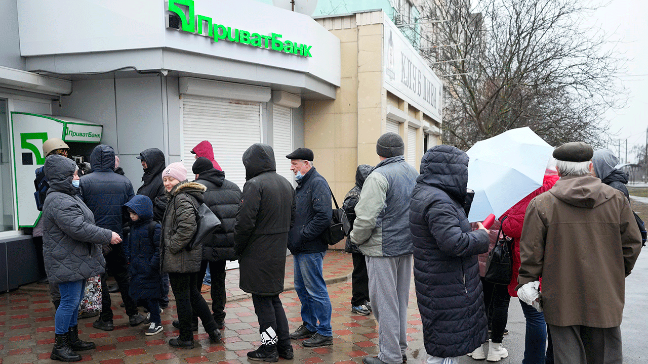 People line up to withdraw their money from an ATM in Mariupol, Ukraine, Thursday, Feb. 24, 2022. 