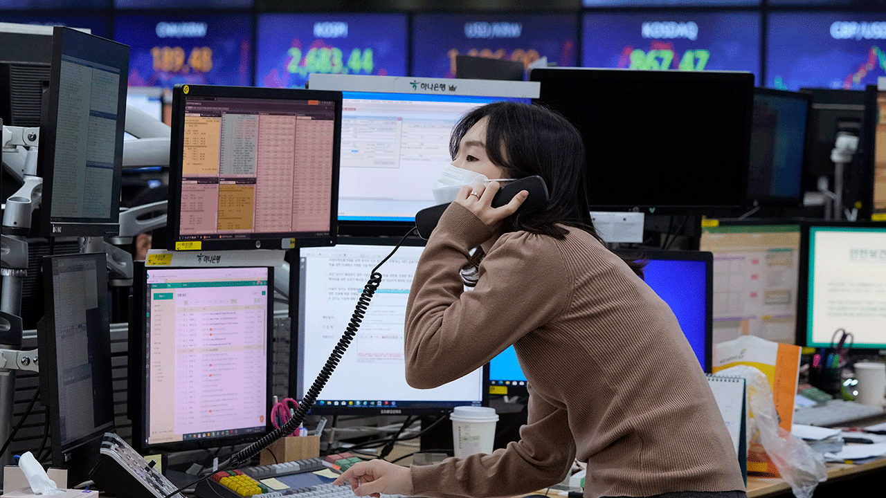 A currency trader talks on the phone at the foreign exchange dealing room of the KEB Hana Bank headquarters in Seoul, South Korea, Thursday, Feb. 24, 2022. 