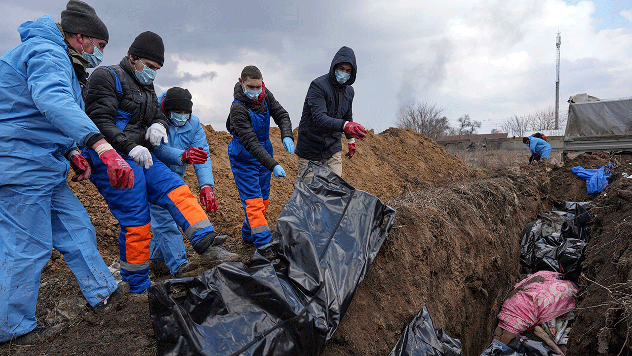 Dead bodies are placed into a mass grave on the outskirts of Mariupol, Ukraine, Wednesday, March 9, 2022, as people cannot bury their dead because of the heavy shelling by Russian forces.