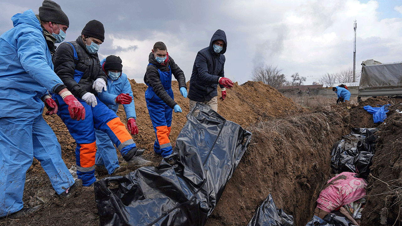 Dead bodies are placed into a mass grave on the outskirts of Mariupol, Ukraine, Wednesday, March 9, 2022, as people cannot bury their dead because of the heavy shelling by Russian forces.?