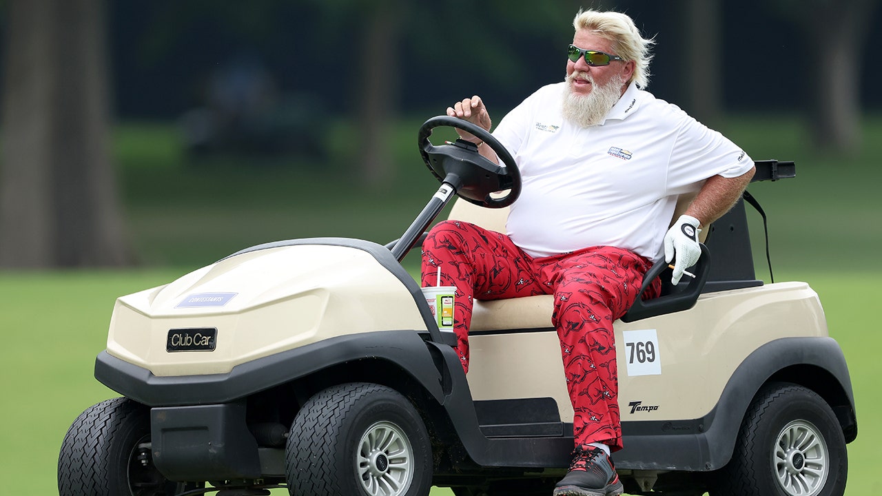 John Daly, the golf’s patron saint, conducts a motorhome interview from the church parking lot