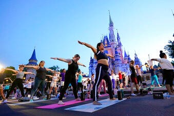 Disney employees celebrate national yoga day in front of Cinderella's Castle