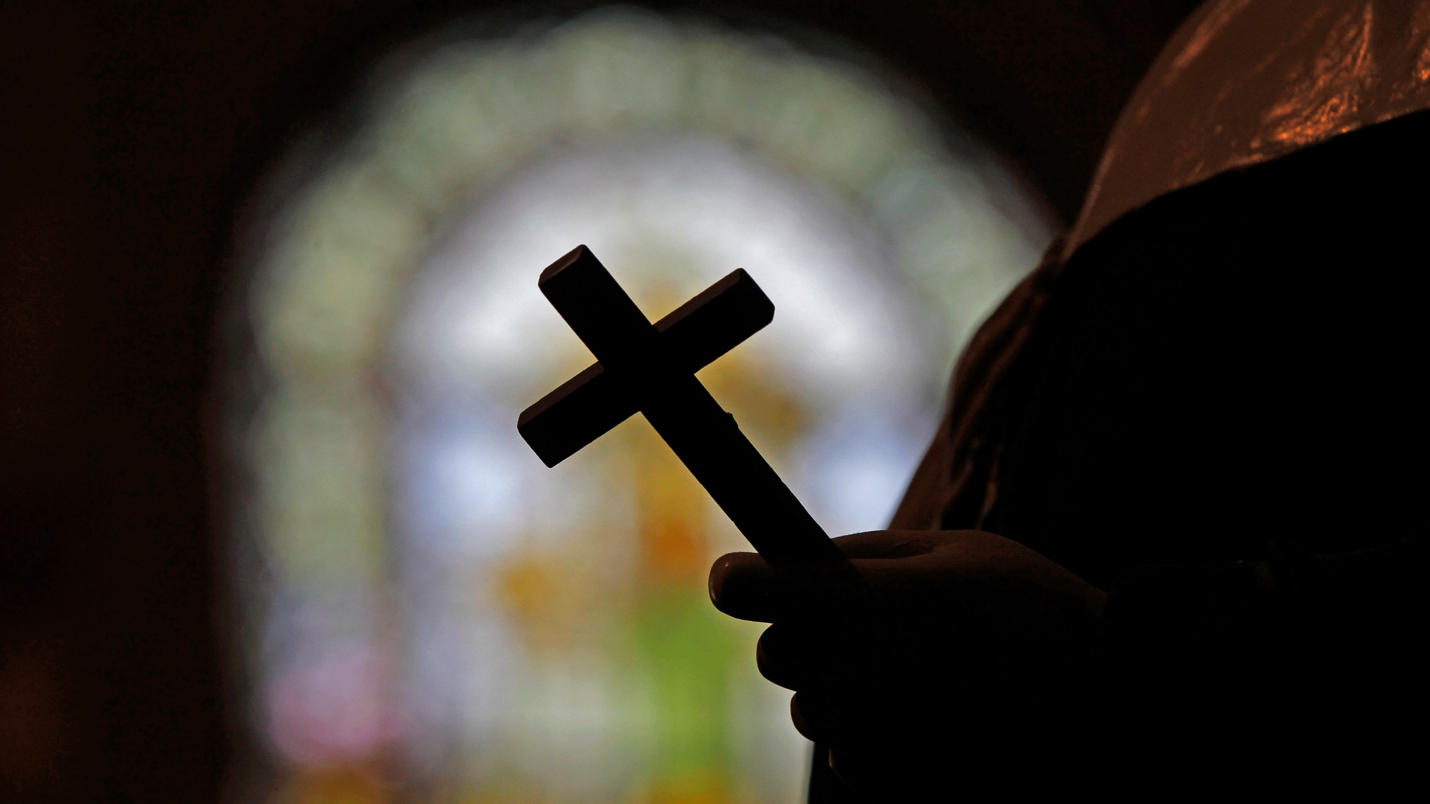 La foto de archivo muestra la silueta de un crucifijo y una vidriera dentro de una iglesia católica en Nueva Orleans. 