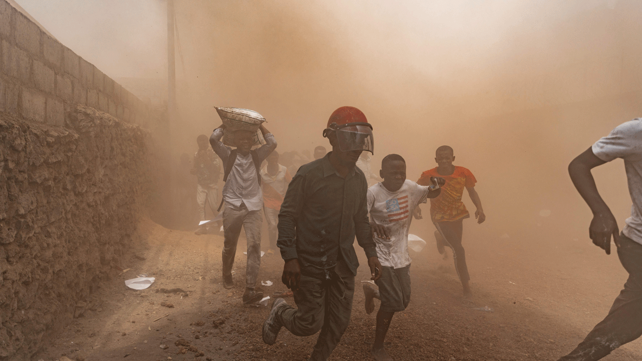 People running to safety in dusty conditions