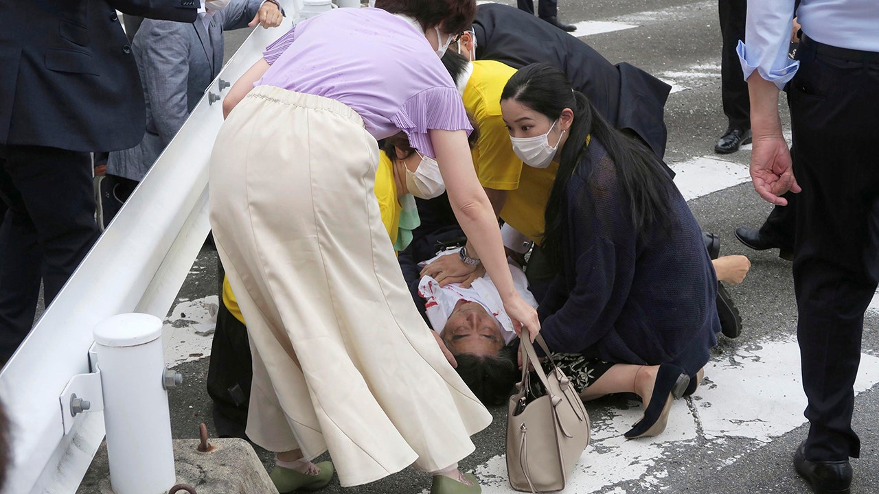 Japan's former Prime Minister Shinzo Abe, center, falls on the ground in Nara, western Japan Friday, July 8, 2022. (Kyodo News via AP)
