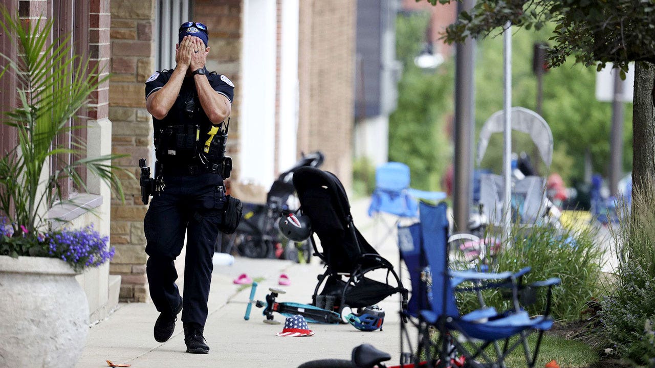 A Lake County, Illinois, police officer walks down Central Avenue in Highland Park on July 4, 2022, after a shooter fired on the northern suburb&apos;s Fourth of July parade. At least six people were killed and at least two dozen injured. (Brian Cassella/Chicago Tribune/Tribune News Service via Getty Images) ()