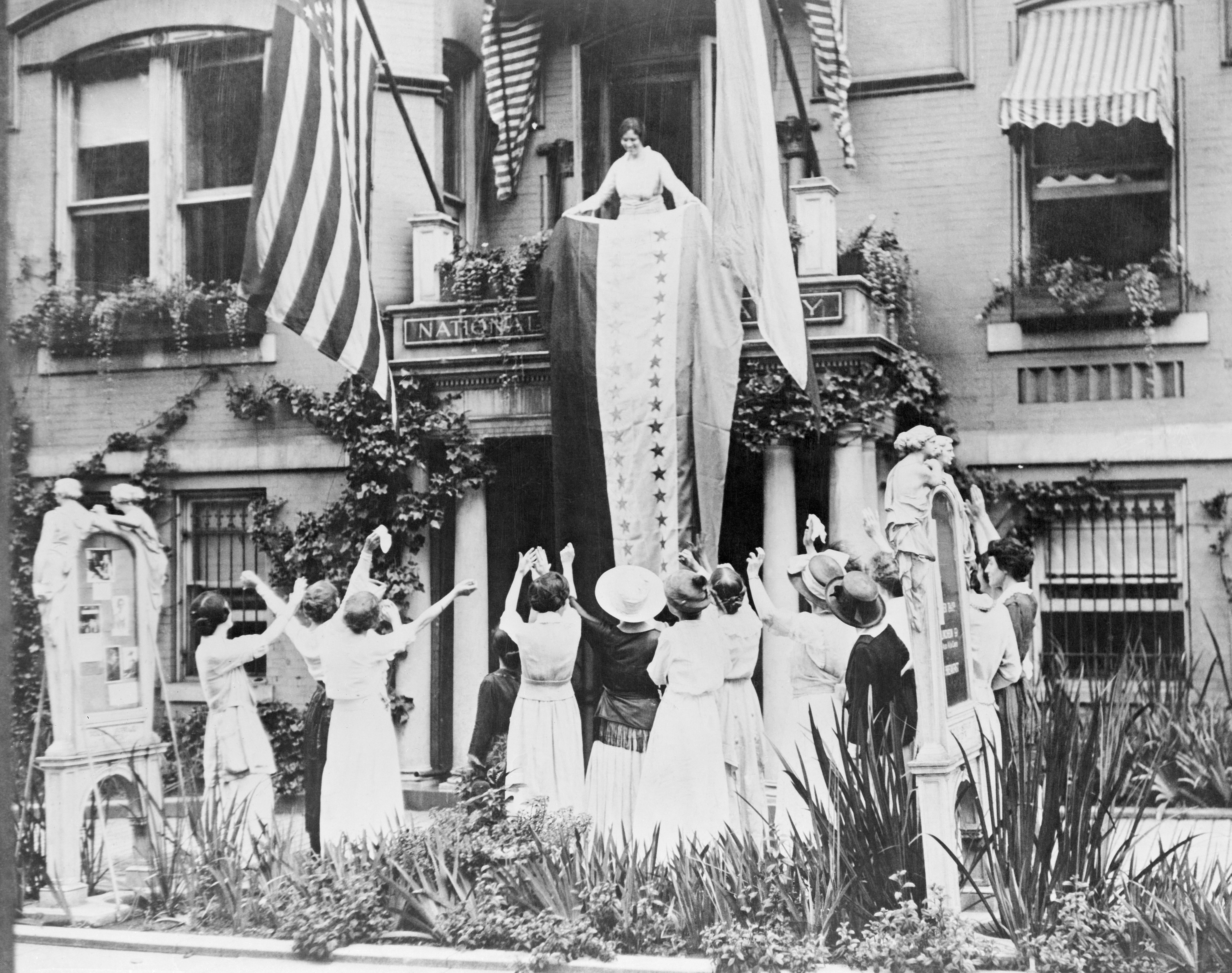 Alice Paul unfurls a banner from the balcony of the National Women's Party headquarters, showing a star for each state which has ratified the 19th Amendment, giving women the right to vote. The women are celebrating the ratification of the amendment by Tennessee, making the amendment law. (Bettmann/Getty Images)