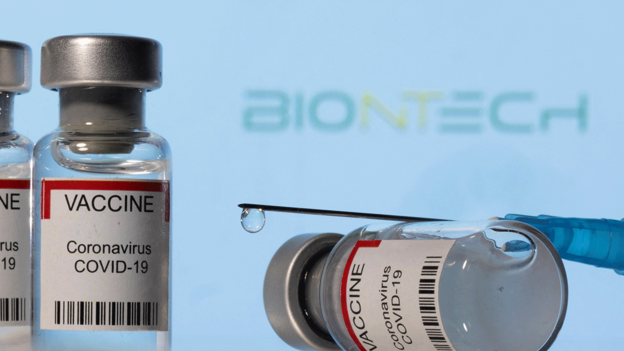 Coronavirus vaccine vials with BioNTech background, needle with drop 