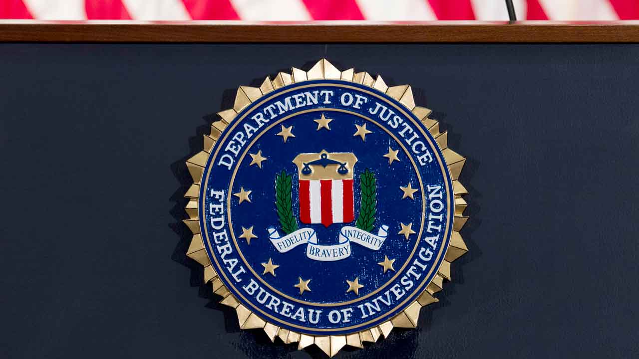 شعار FBI وختم يظهران أسفل العلم الأمريكي