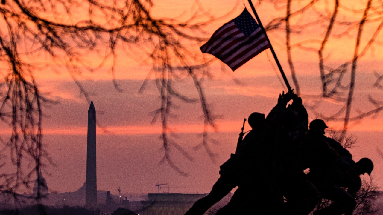 The American flag flies above the Iwo Jima Memorial, with the Washington Monument in the distance in Arlington, Virginia. Find out interesting facts about this solemn holiday by clicking the link above. (Samuel Corum/Getty Images)