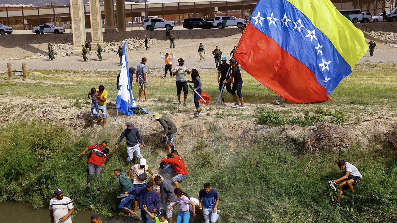 La patrulla fronteriza dispara bolas de pimienta a los migrantes venezolanos después de que un oficial fue atacado con un asta de bandera, dicen las autoridades