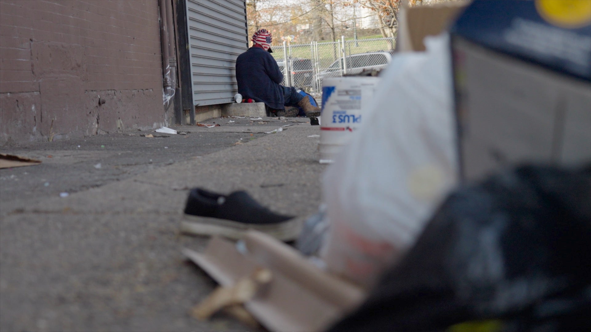 Addict in front of trash