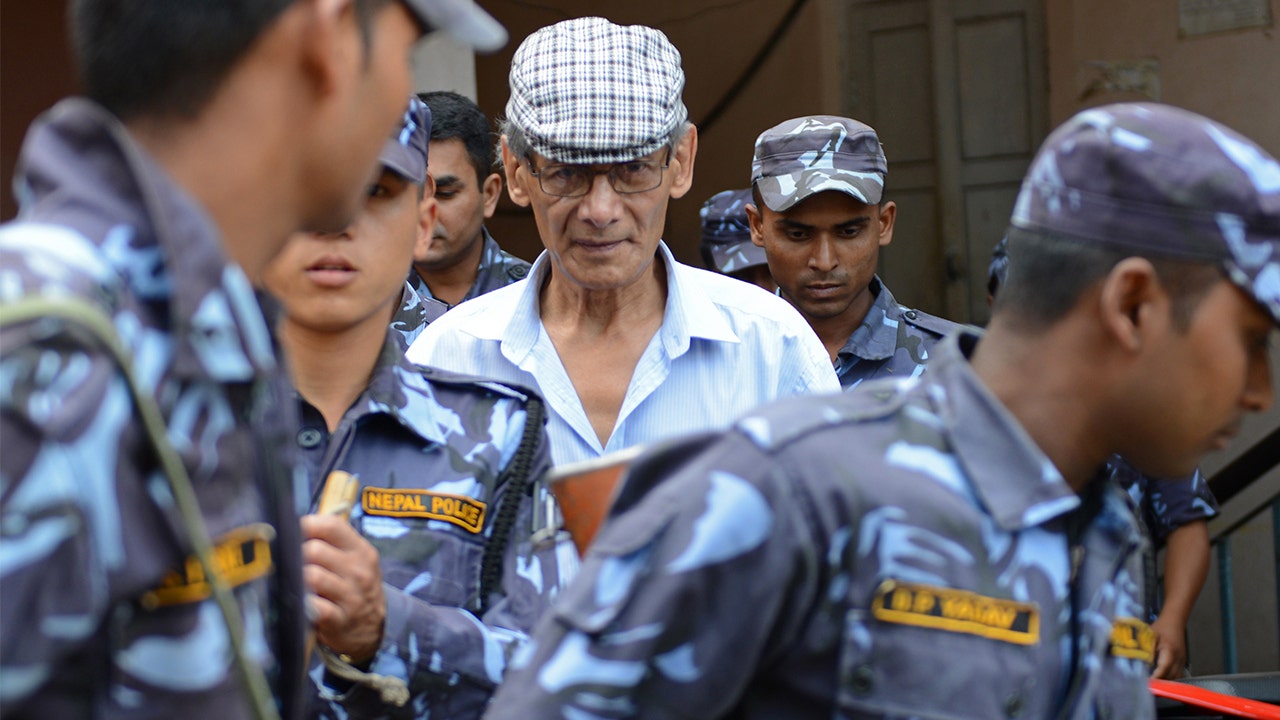 French serial killer Charles Sobhraj is escorted by Nepalese police at a district court for a hearing on a case related to the murder of Canadian backpacker Laurent Ormond Carriere, in Bhaktapur on June 12, 2014. (PRAKASH MATHEMA/AFP via Getty Images)