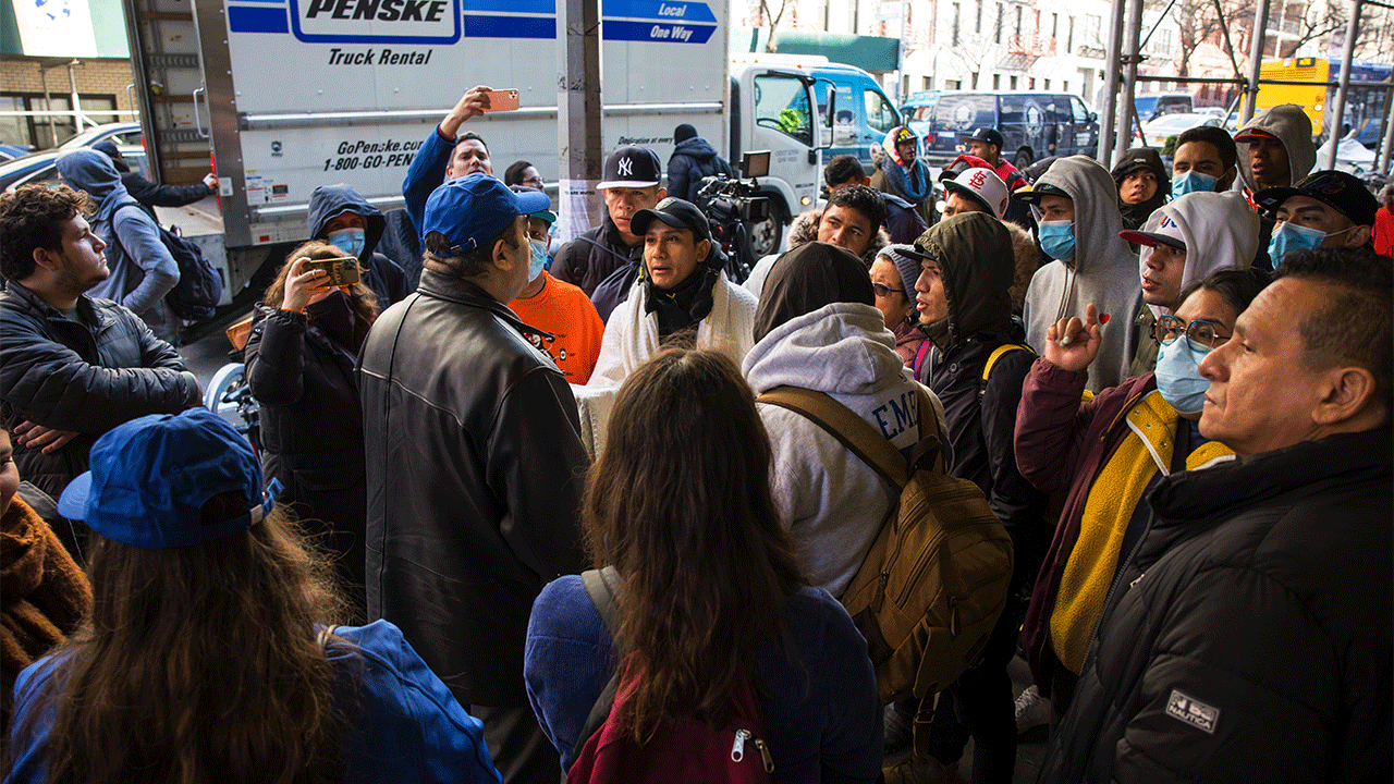 A member of the mayor's immigration office speaks with migrants who were camping out in front of the Watson Hotel after being evicted on Jan. 30, 2023, in New York City.